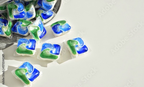 Multi-colored capsules for dishwashers on a white background.