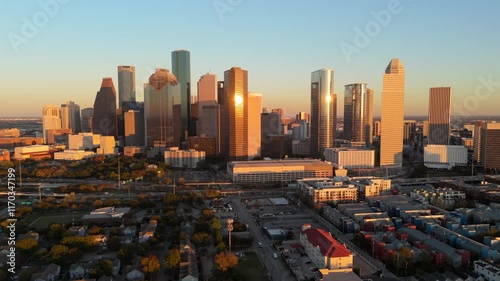 Cinematic aerial view of stunning downtown skyline of Houston, Texas, during a beautiful sunset, emphasizing citys remarkable architecture alongside its vibrant atmosphere, car freeway interchange 