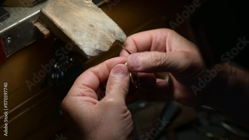 Goldsmith carefully crafting intricate golden pendant, hammering delicate details with focused expertise in detailed metalworking process