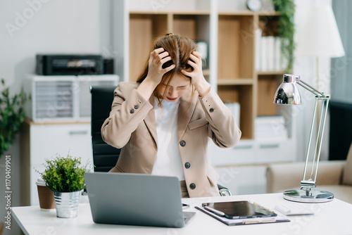 Asian woman feeling migraine head strain.Overworked businesswoman financier while working
