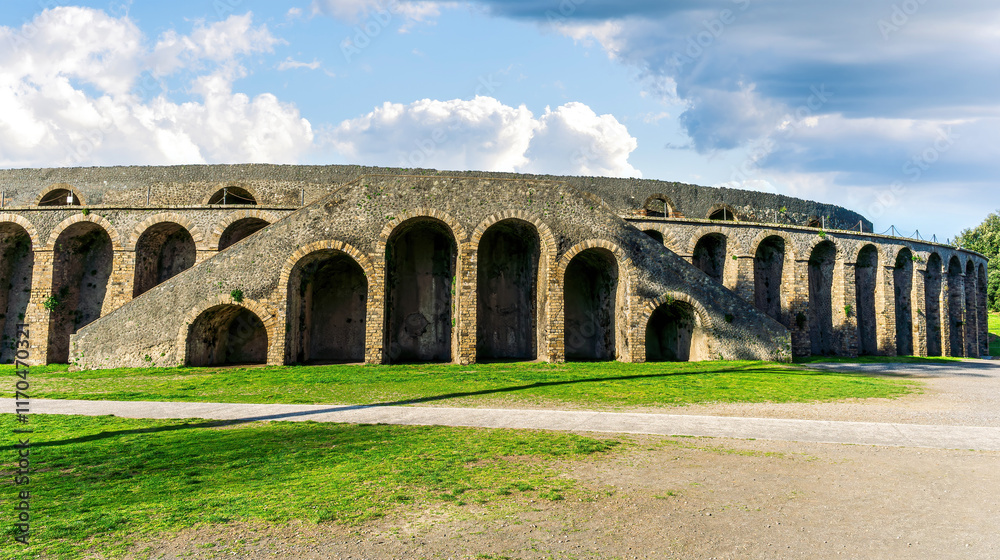 Fototapeta premium landscape of old ancient building of Roman arena with greeen grass foreground and beautiful blue cloudy sky background