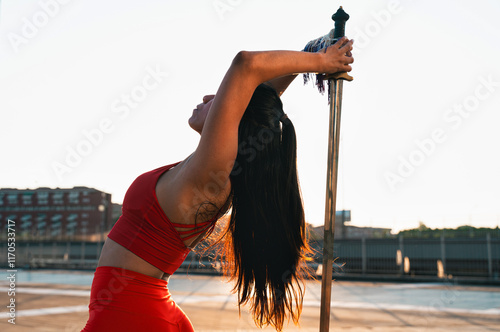 Chinese young woman practicing wushu kung fu with weapons outdoor. Young girl training martial arts form for the competition. photo