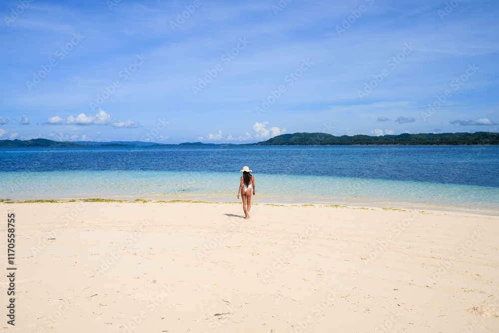 Young asian woman walking to sea, Siargao, Philippines Young asian woman walking to sea, Siargao, Philippines