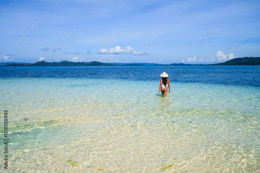 Young asian woman walking in the turquoise water, Siargao, Philippines Young asian woman walking in the turquoise water, Siargao, Philippines