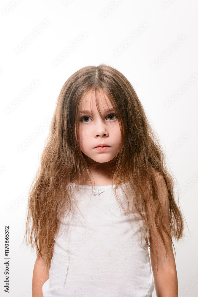 A serious-looking girl with long, unkempt brown hair. She's wearing a simple white tank top. The image is shot against a plain white backdrop. A serious-looking girl with long, unkempt brown hair. She's wearing a simple white tank top. The image is shot against a plain white backdrop.
