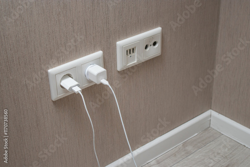 Close up of phone charger plugged in the socket