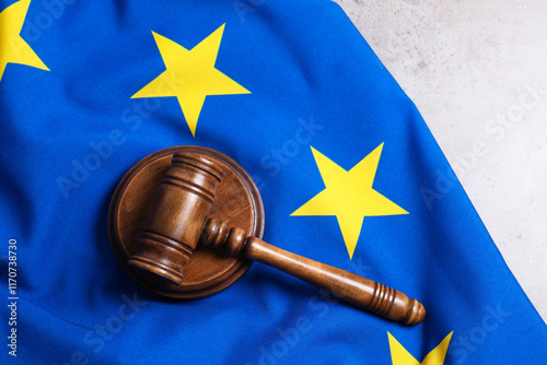 Judge's gavel and flag of European Union on grey table, top view