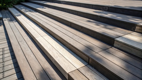 An abstract view captures the layered arrangement of composite decking boards with varying lengths creating dynamic shadows. The interplay of light and dark emphasizes the
