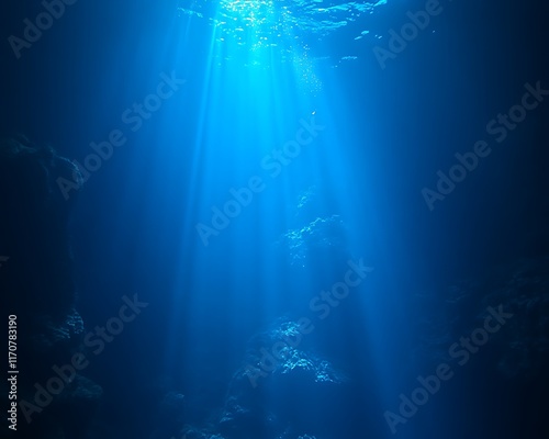 Sunbeams penetrate deep ocean, illuminating dark underwater cavern.