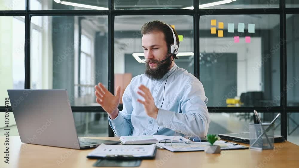 In headphones. Man is sitting in the office by the laptop, conception of business.