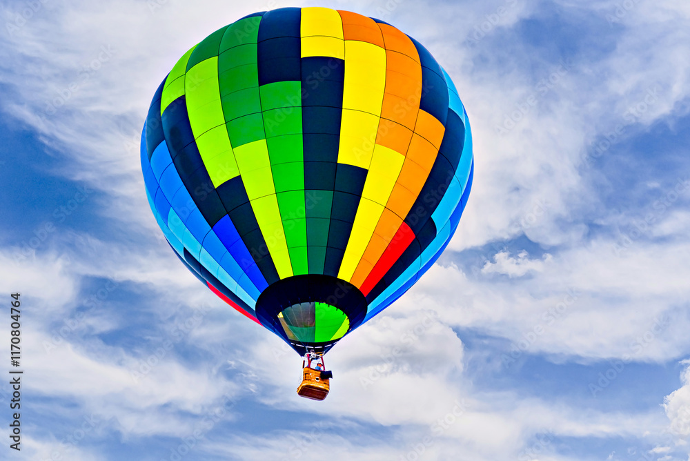 Naklejka premium Colorful hot air balloon flying over blue sky with white clouds 
