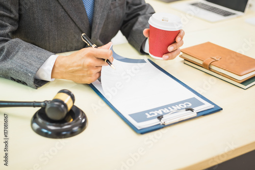 Male lawyer diligently examines documents placed on his desk, demonstrating his professionalism and dedication to finding legal truth, analyzing ideas, and pursuing justice with relentless focus. photo