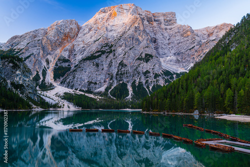 The Lago di Braies or the Pragser Wildsee in the Italian Alps Dolomites early in the morning sunrise with the reflection and wooden boats. photo