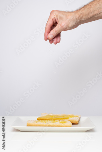 Adding salt to a plate of fresh bread with virgin olive oil. Copy Space.