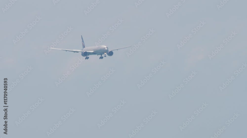 Airliner approaching landing, side view. Jet plane with unrecognizable livery descending, arriving, long shot. Aircraft in the blue sky Airliner approaching landing, side view. Jet plane with unrecognizable livery descending, arriving, long shot. Aircraft in the blue sky