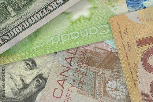 US $100 bill peeking out from under Canadian dollar bills. Foreign Exchange Market. Financial Concept