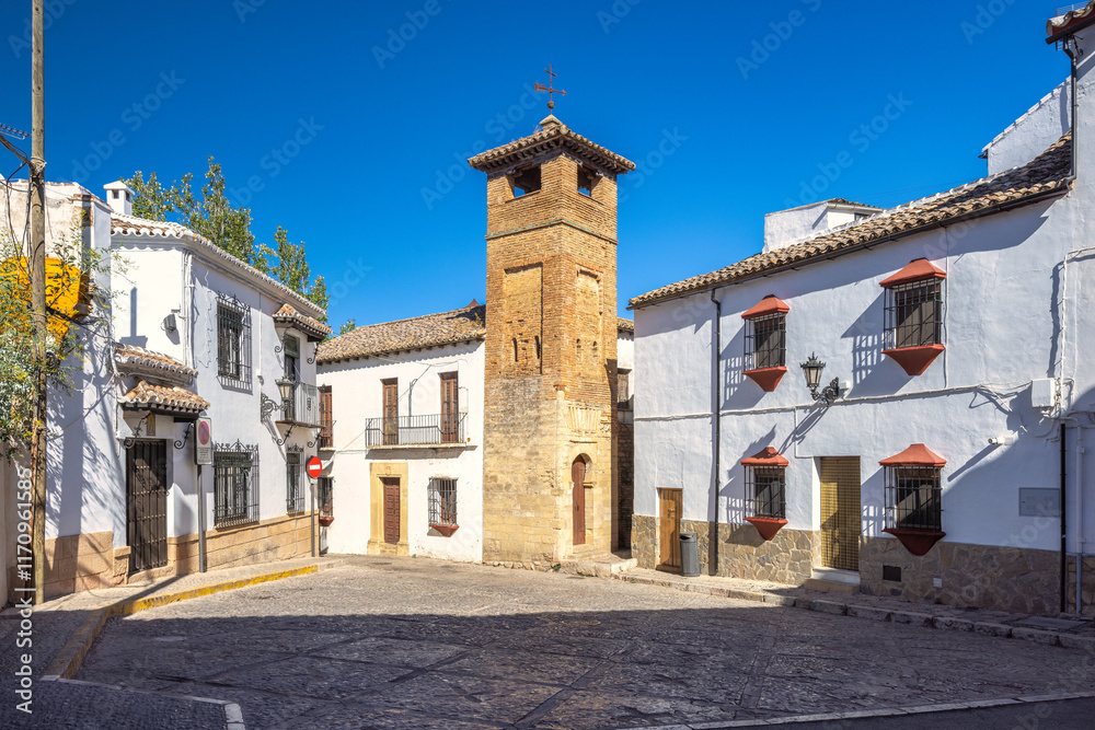 Ronda town in Spain. Historic town square with a distinctive stone tower and whitewashed buildings under a vibrant blue sky. Ronda town in Spain. Historic town square with a distinctive stone tower and whitewashed buildings under a vibrant blue sky.