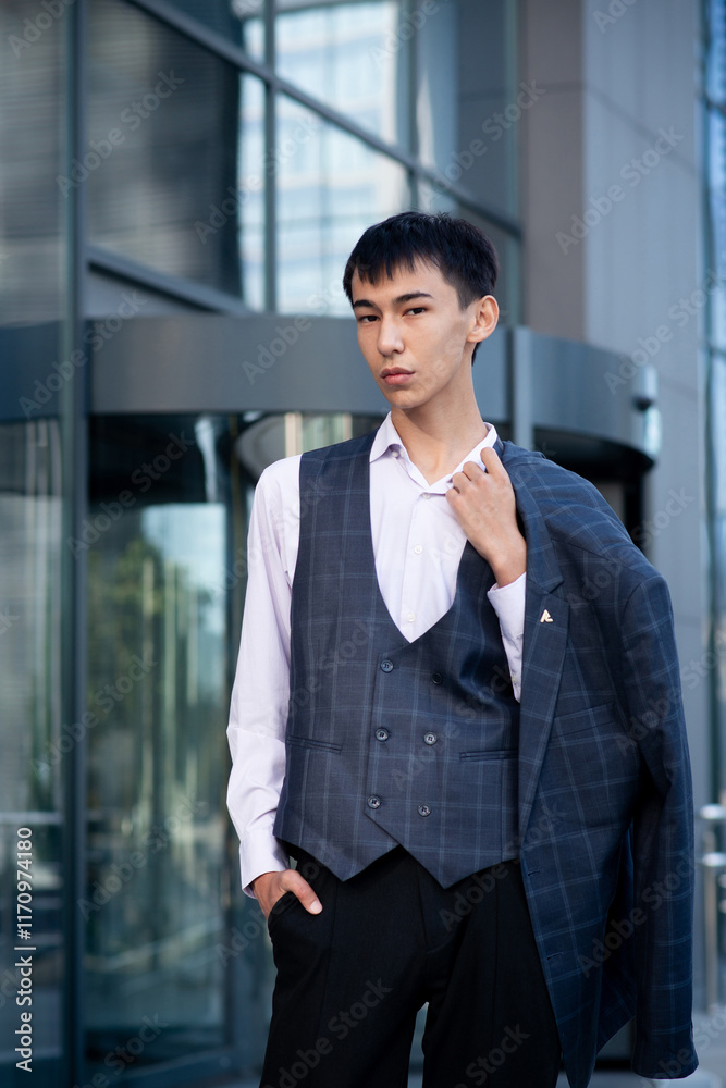 Oriental man in suit, business person, manager stands on city center background Oriental man in suit, business person, manager stands on city center background