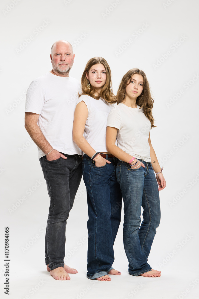 Studio portrait of father with two teenage kids. Studio portrait of father with two teenage kids.