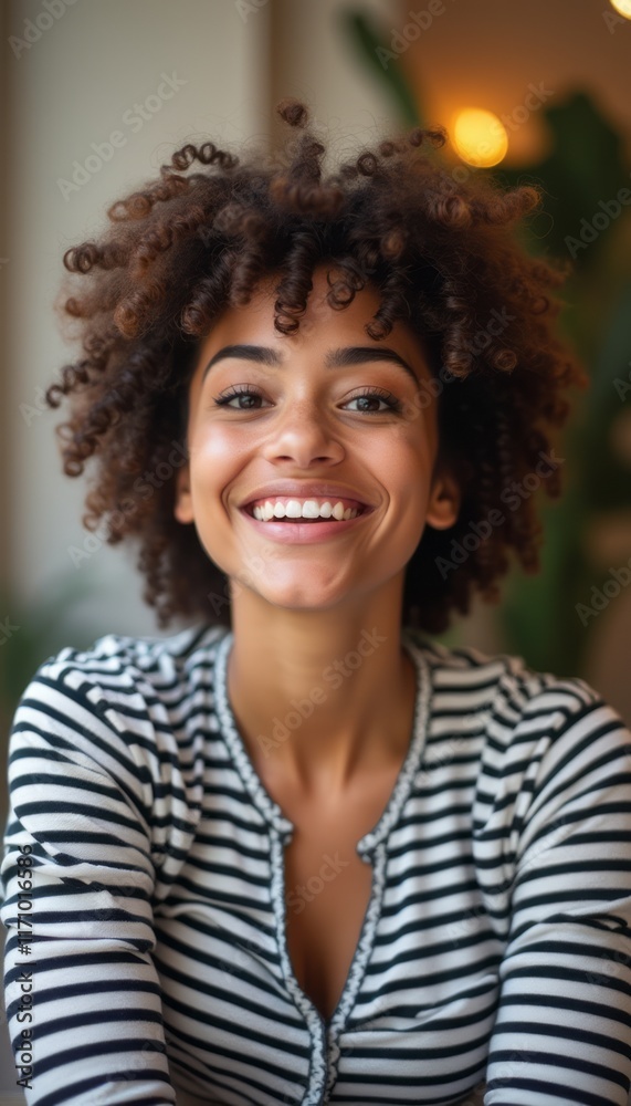 A cheerful young woman with beautiful curly hair beams with joy, wearing a striped shirt. Her radiant smile and warm expression create an inviting atmosphere, perfect for capturing the essence of A cheerful young woman with beautiful curly hair beams with joy, wearing a striped shirt. Her radiant smile and warm expression create an inviting atmosphere, perfect for capturing the essence of