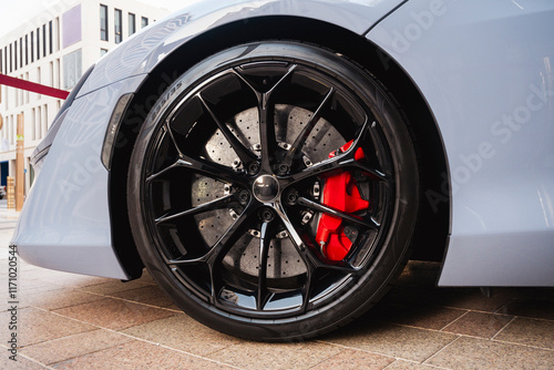 Close-up sports car red brake caliper with tire and black rim