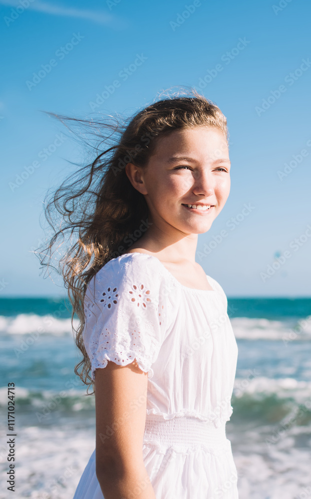 Cheerful girl walking on beach near waving sea Cheerful girl walking on beach near waving sea