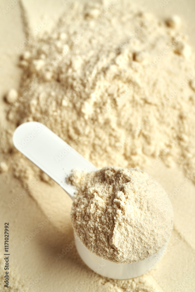 Fototapeta premium Whey protein powder in a plastic measuring spoon