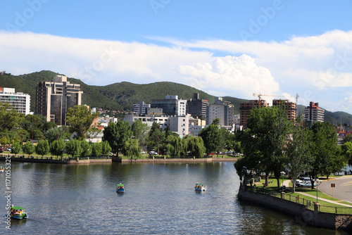 
Landscape of the city of Villa Carlos Paz, Cordoba, Argentina. View of San Roque Lake with boats with tourists sailing and buildings and mountains in the background.