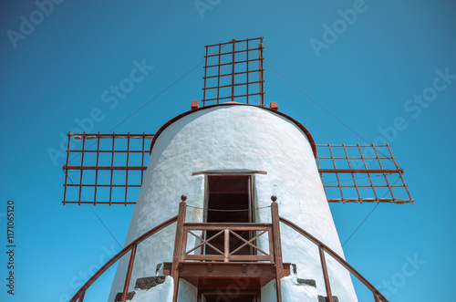 Rustic White Windmill with Wooden Accents Standing Against a Pristine Blue Sky – A Timeless Piece of Traditional Architecture and Cultural Heritage