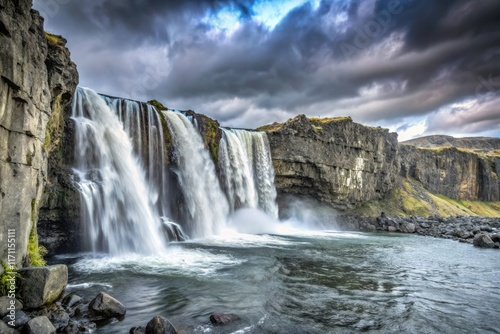 Epic waterfall cascades down Icelandic cliffs; a breathtaking landscape of power and drama.