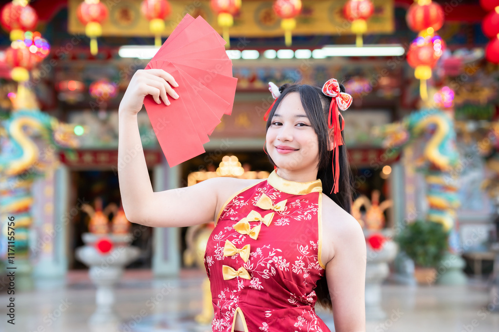 Portrait smiles Asian young woman wearing red cheongsam dress holding red envelopes decoration for Chinese new year festival celebrate culture of china at Chinese shrine Public places in Thailand