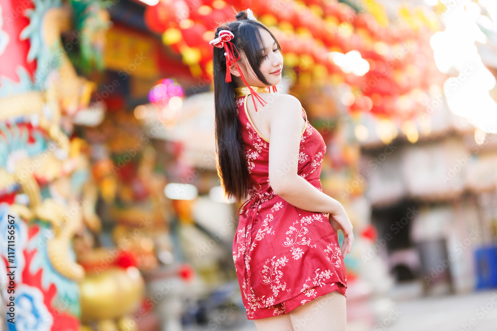 Portrait beautiful cute smiles Asian young woman wearing red cheongsam dress traditional decoration for Chinese new year festival celebrate culture of china at Chinese shrine Public places in Thailand