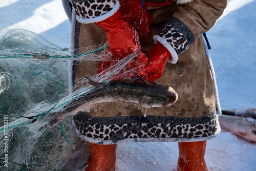 Ice fishing on a frozen lake in cold winter photo