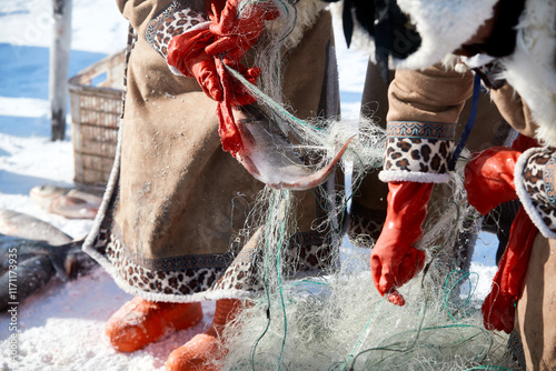 Ice fishing on a frozen lake in cold winter photo