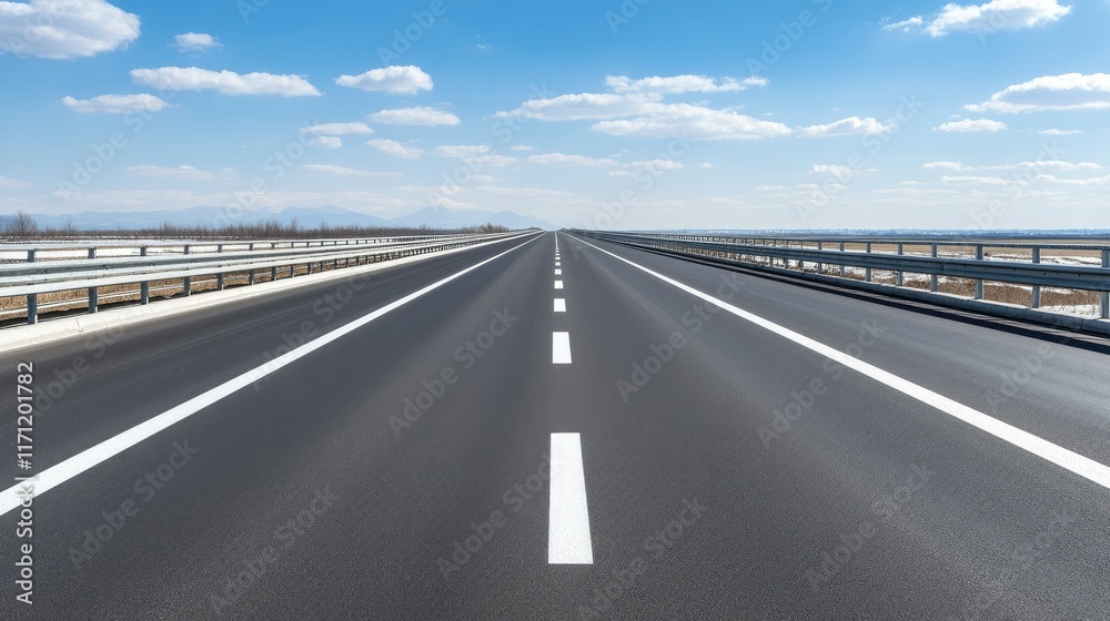 A quiet highway stretches towards snow-capped peaks, framed by mountains and fluffy clouds, with water flowing underneath the bridge A quiet highway stretches towards snow-capped peaks, framed by mountains and fluffy clouds, with water flowing underneath the bridge