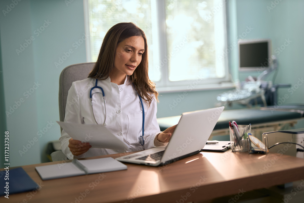 Female medical expert working on documents and laptop in the office. Female medical expert working on documents and laptop in the office.
