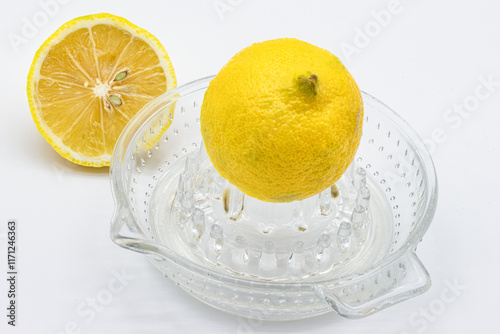 Glass Lemon squeezer with half of lemon on white background. Copy space