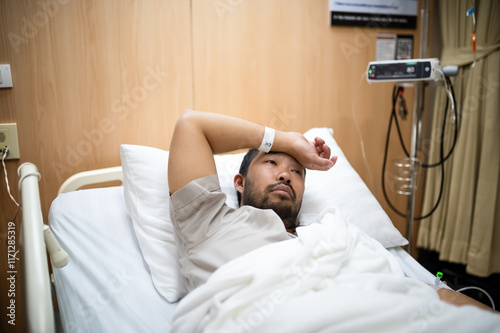 The patient was lying depressed on a hospital bed with an IV still attached to his arm.