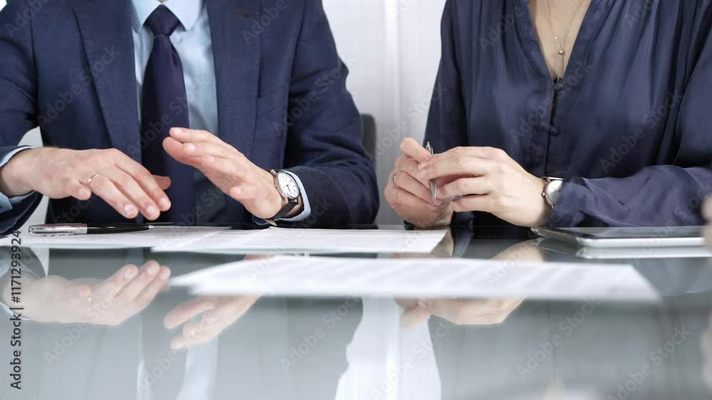 Business partners or lawyers are discussing contract papers during a meeting, negotiating and making decisions together. Business people concept, close up