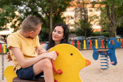 Mother and son with cerebral palsy enjoying playground time photo