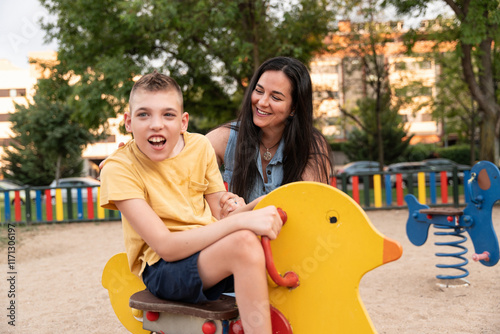 Joyful moment of a mother with her disabled son in the park photo