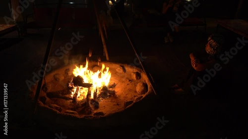 making a fire in nature in a  desert tour , brazier with embers and burning wood - night in camping and adventure on a tourist safari during a backpacking trip in Morocco Sahara desert 