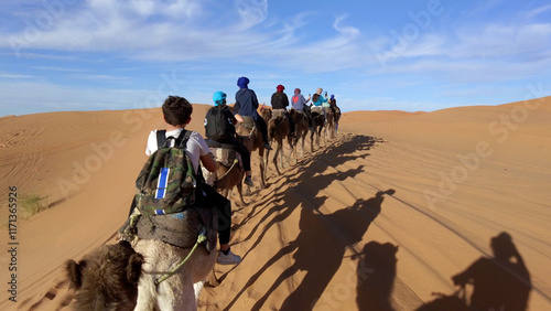 Obraz na płótnie Caravan going through the sand dunes in the Sahara Desert, Morocco - Merzuga - tourist visit the desert on camels during the holidays - adventure and freedom during a trip , safari - organized travel w salonie