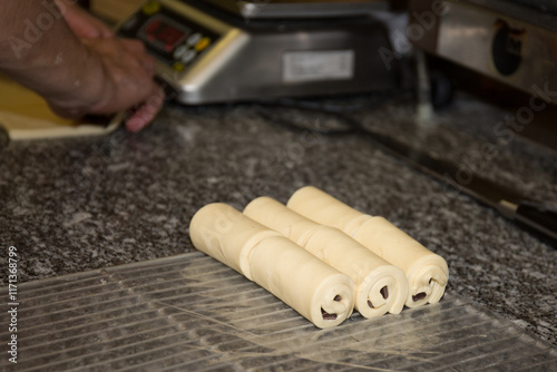 Chocolate roll croissants spreads on baking tray in bakery oven photo