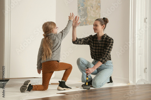 Fotografie Mother and her little daughter working together on renovating and remodeling the