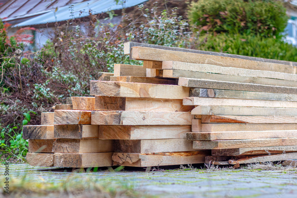 On the construction site there are even rows of wooden planks, neatly laid, ready to be used for further construction work. On the construction site there are even rows of wooden planks, neatly laid, ready to be used for further construction work.