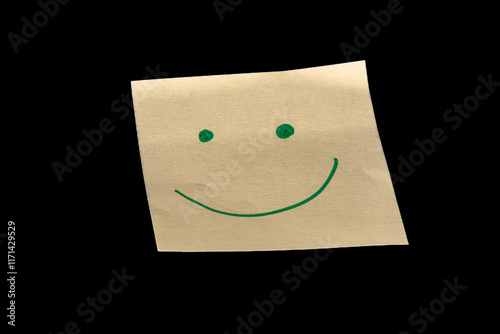 Yellow sticky note on a black background, featuring hand-drawn dots as eyes and an upward-curved line as a mouth, creating a joyful, happy, and calm expression