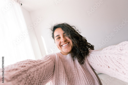 Young latin woman enjoying a cozy day at home in a comfortable sweater photo