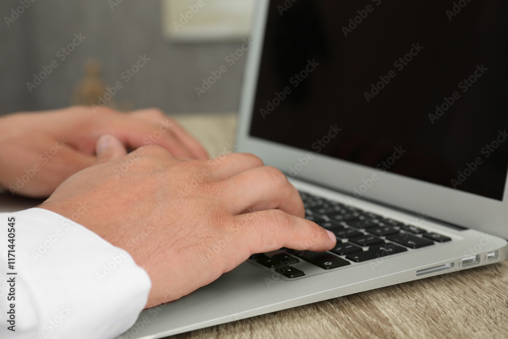 Businessman using laptop at wooden table, closeup. Modern technology Businessman using laptop at wooden table, closeup. Modern technology