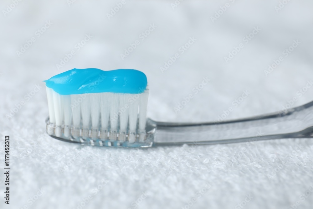 Toothbrush with toothpaste on white towel, closeup Toothbrush with toothpaste on white towel, closeup